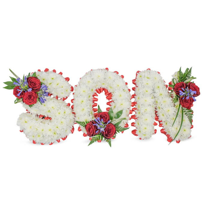 A poignant, lovingly fashioned memorial arrangement that spells the word SON in three-dimensional capital letters, set against a simple white background so every texture can be read clearly. Each letter is composed of densely clustered white spray chrysanthemums that form a soft, pillowy surface; the flowers are arranged to preserve round, even edges while allowing the blooms to breathe, producing a serene matte of white. The perimeter of each character is neatly outlined with a vivid red satin ribbon, pleated into a scalloped border which both protects the blooms and heightens the contrast between the white face and the surrounding space. Tasteful accent clusters add colour and structure: groups of deep red roses-open and velvety-sit alongside tall, blue-purple spike flowers (similar to Liatris or delphinium) and layered dark green foliage including fern fronds and trailing leaves. Those clusters are positioned with care: on the upper-left curve of the S, the bottom centre of the O, and cascading from the top-right of the N, lending a natural flow across the three letters. As a local florist serving Hatch End, Pinner and the Broadway area, I imagine this tribute brought into a chapel on a soft, grey morning or placed by a family at the graveside; the colours speak of purity, abiding love and solemn remembrance. This bespoke floral lettering is crafted to convey respect and consolation - a thoughtful, personal homage to a beloved son at a funeral or memorial service.